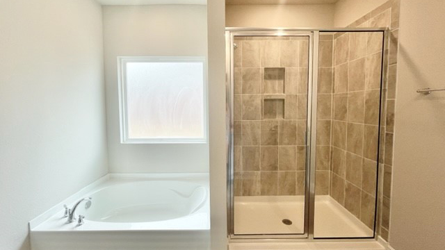 Tiled shower and sparkling white soaker tub.