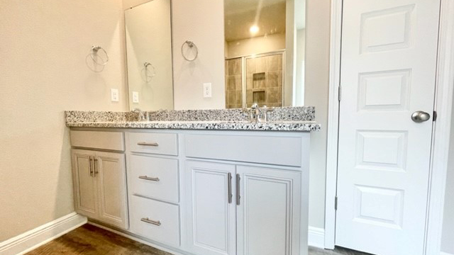Primary bathroom with double sinks in a white vanity.
