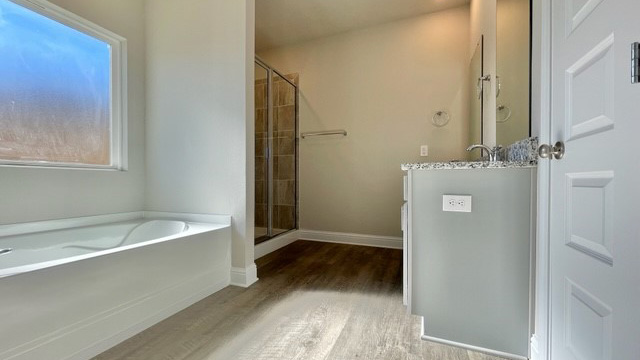 Primary bathroom with garden tub and tiled shower.