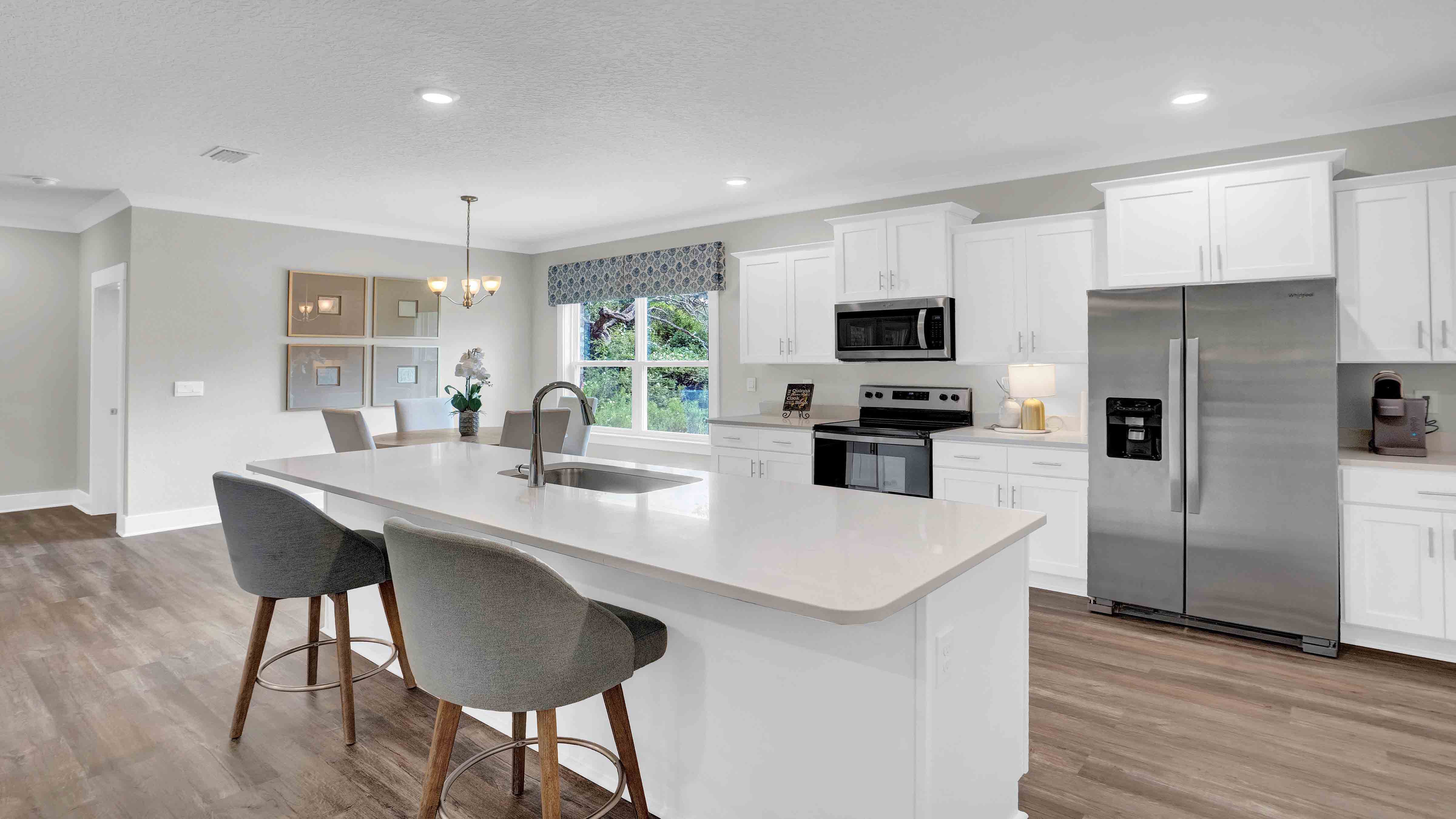 White kitchen with stainless steel appliances in the Destin floorplan.