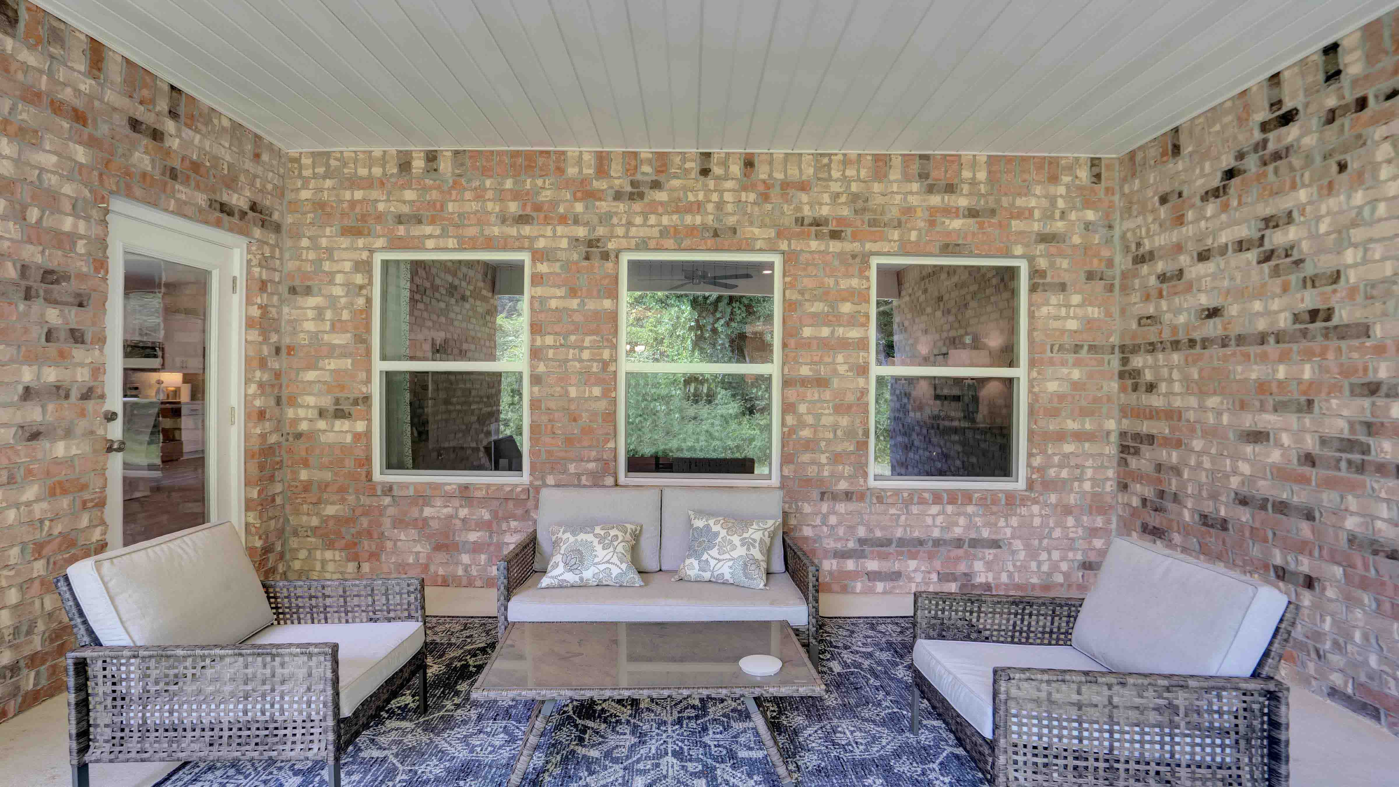 Covered back porch with furniture.