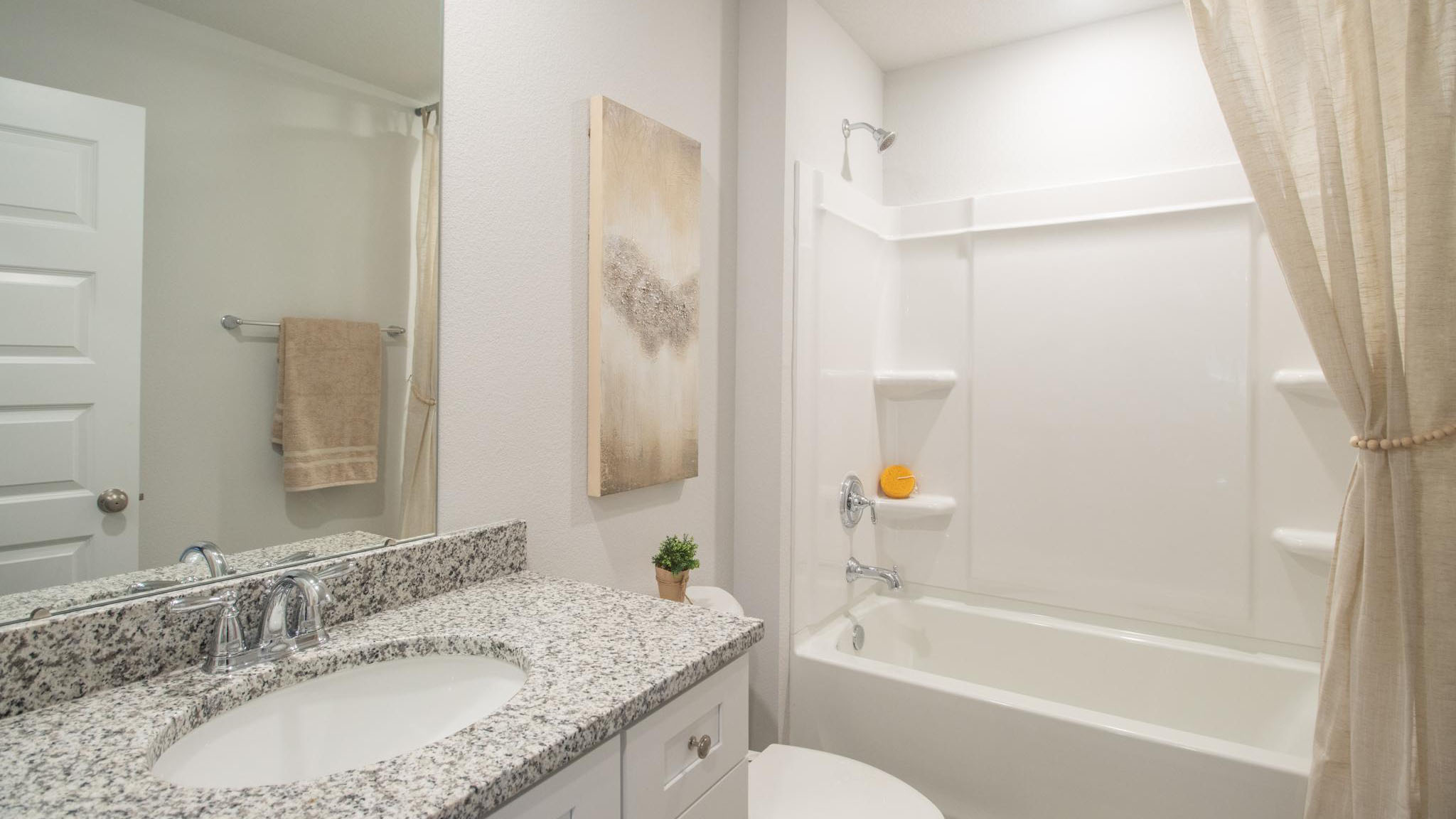 The guest bathroom with vanity and granite counter and shower/tub combination.