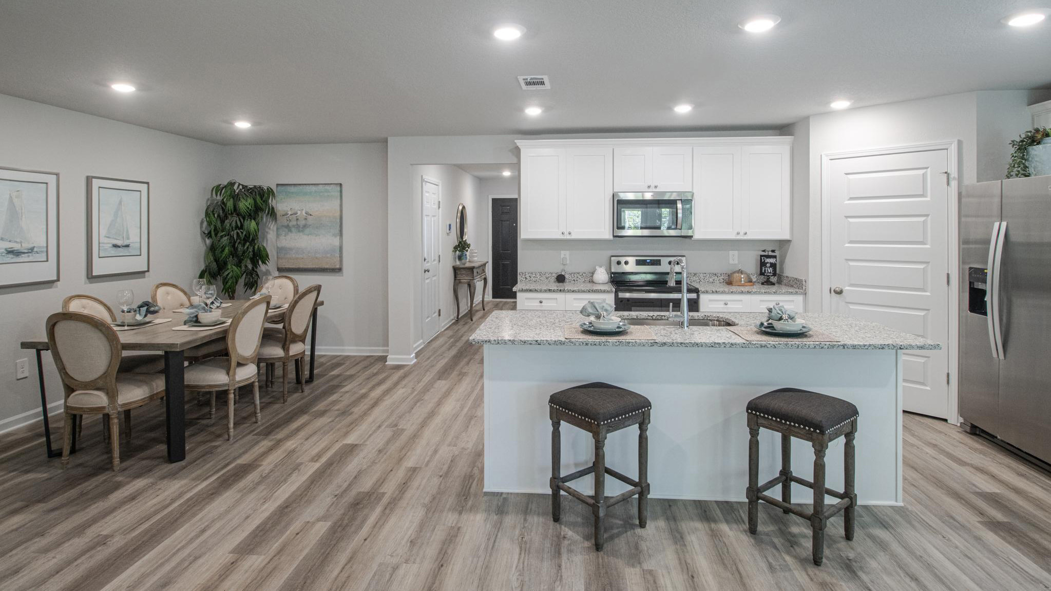The kitchen with white shaker-style cabientry and island with granite countertop.