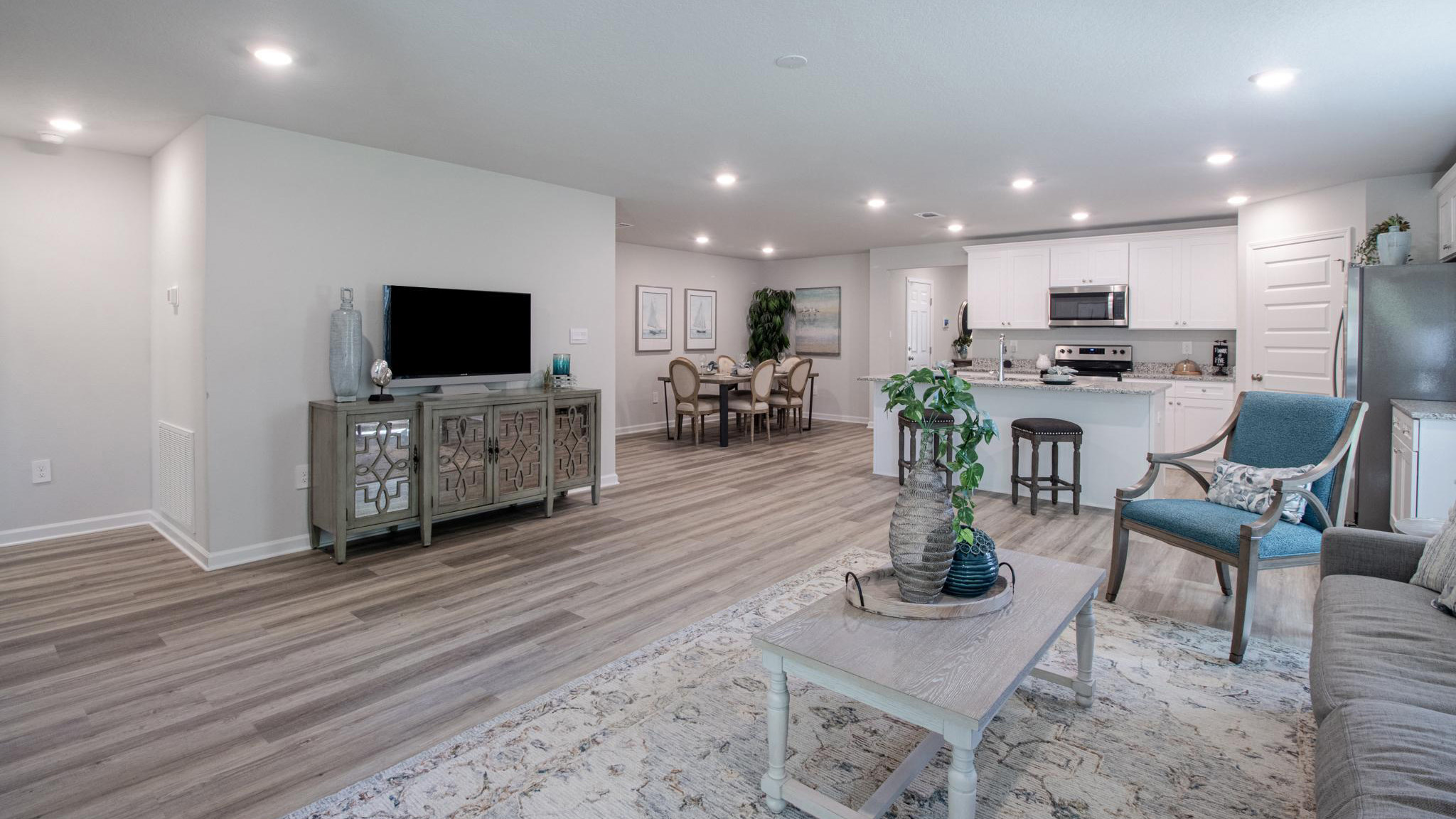 The living room with open concept to kitchen and dining area.