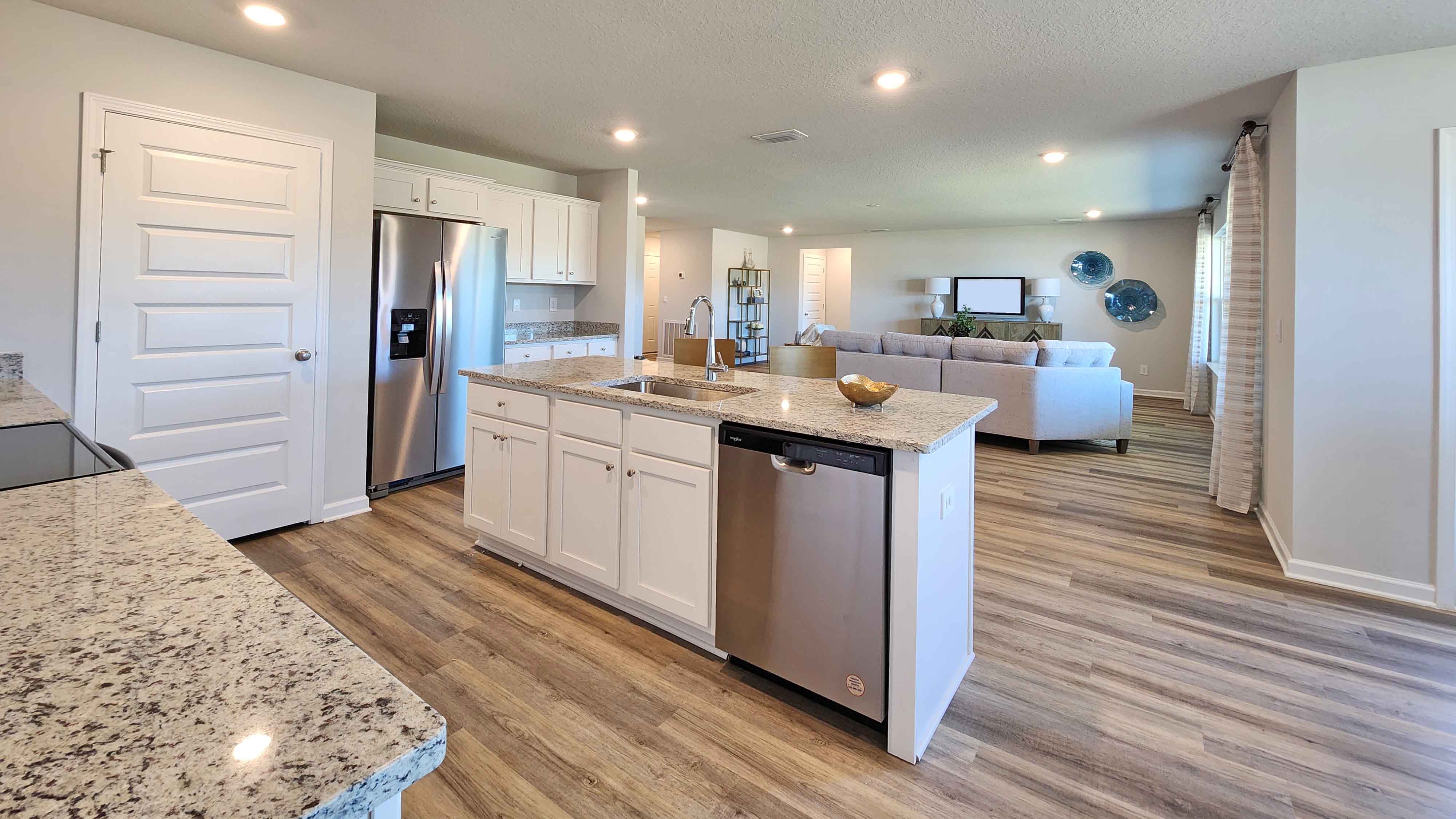 The Denton kitchen with white shaker-style cabinetry and granite counter island.