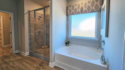 Primary bathroom with tiled shower and garden tub.