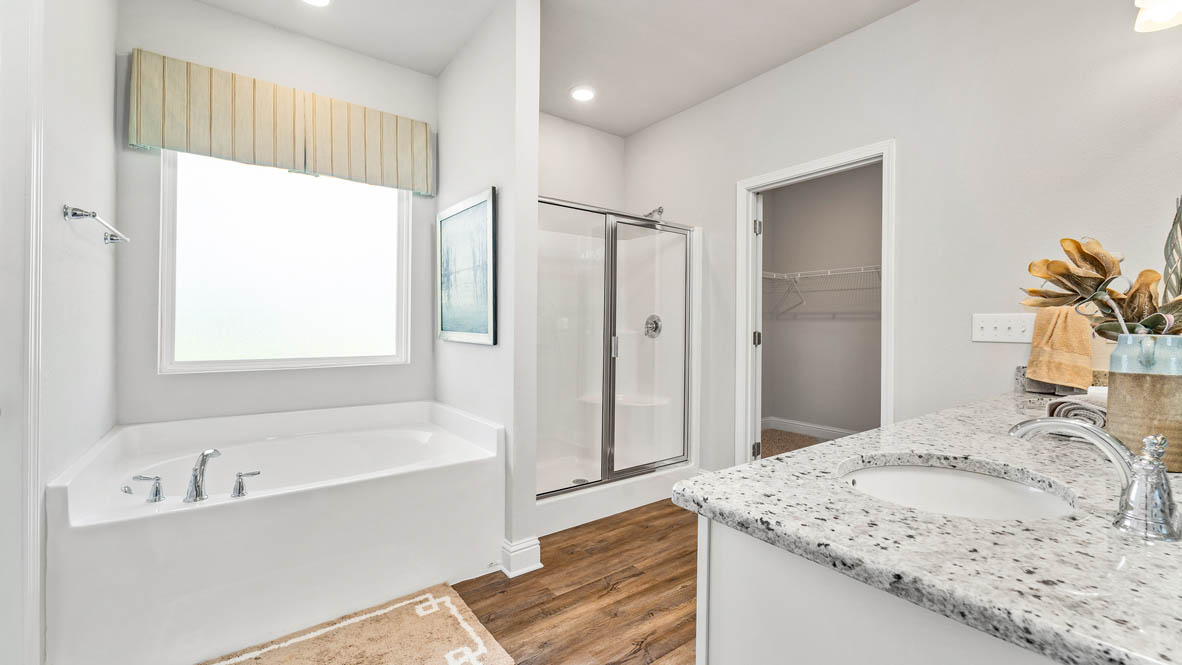 Primary ensuite with dual vanity, tiled shower and garden tub.