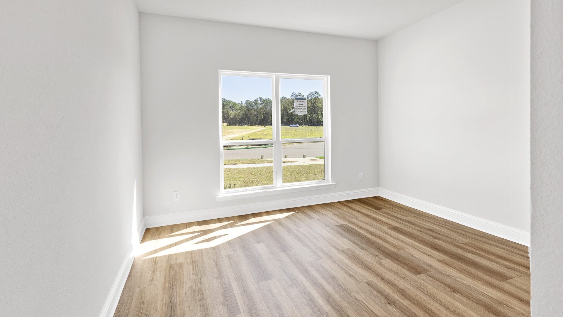 Guest bedroom with large window and neutral walls in Mobile.