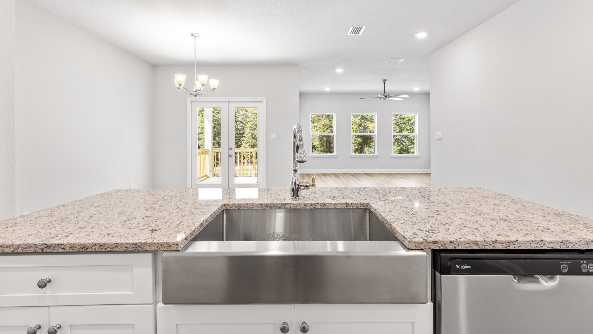 Large central island with granite countertop, stainless farmhouse undermount sink and built in dishwasher in Mobile.