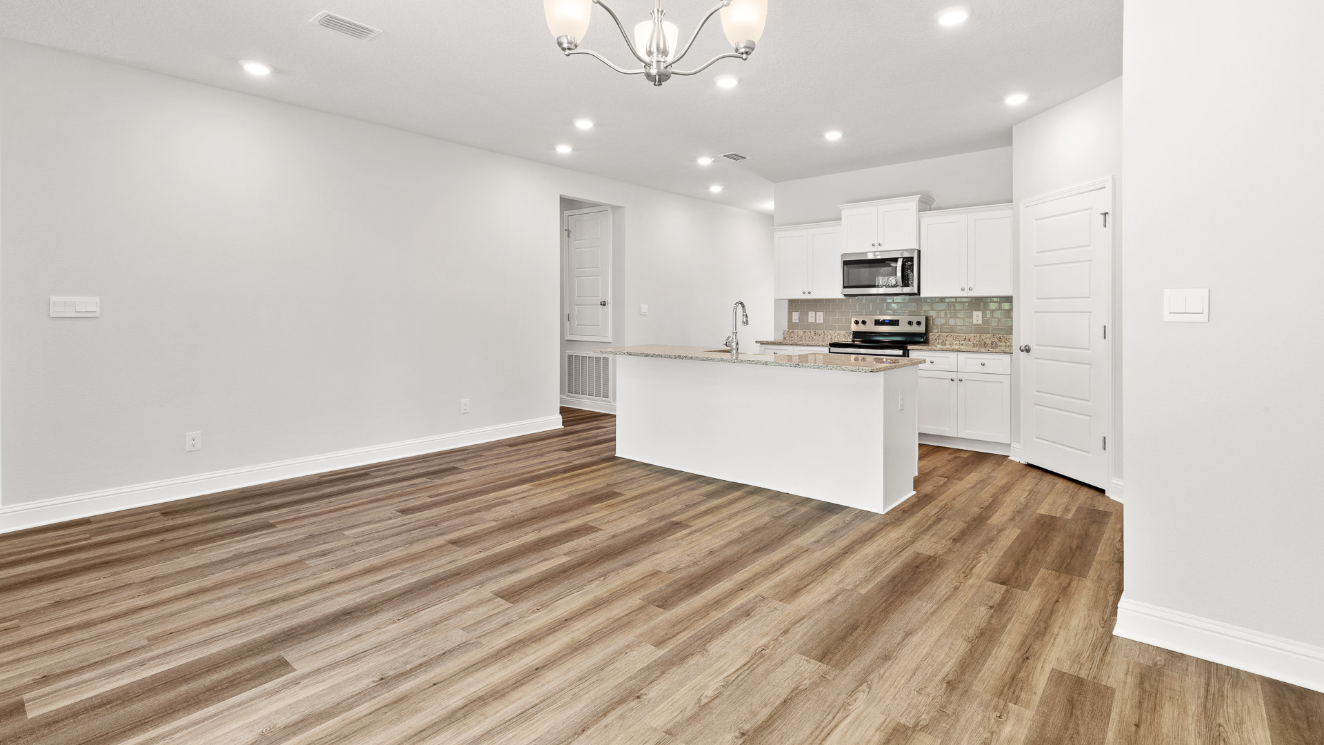 Spacious living and kitchen area with recessed lighting and high ceilings in the Arlington built by D.R. Horton.