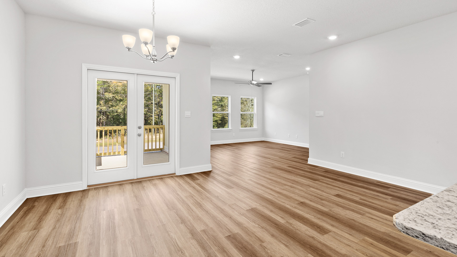 Large open living area with luxury vinyl plank and natural sunlight in a new D.R. Horton community.