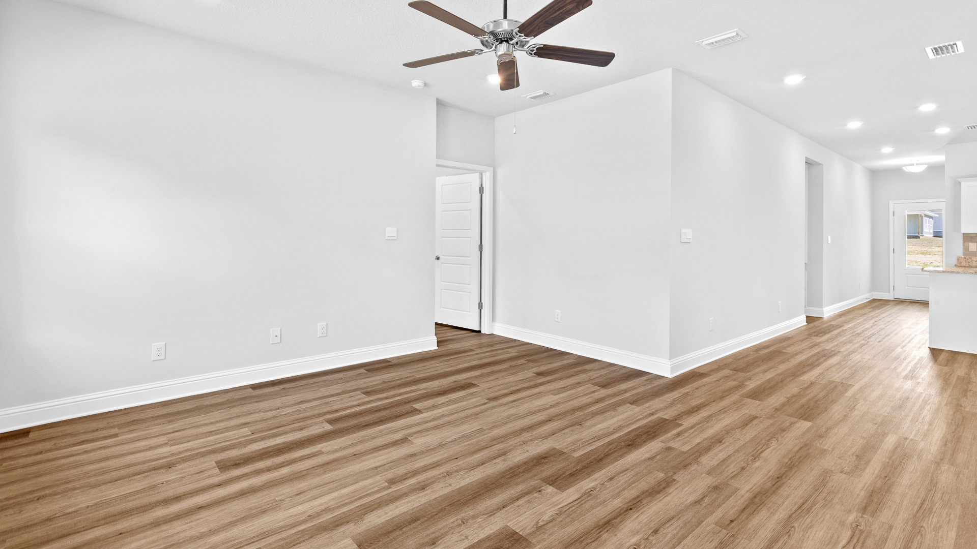 Open concept family room with recessed lighting and light colored luxury vinyl and neutral tones in Hawkins Manor.