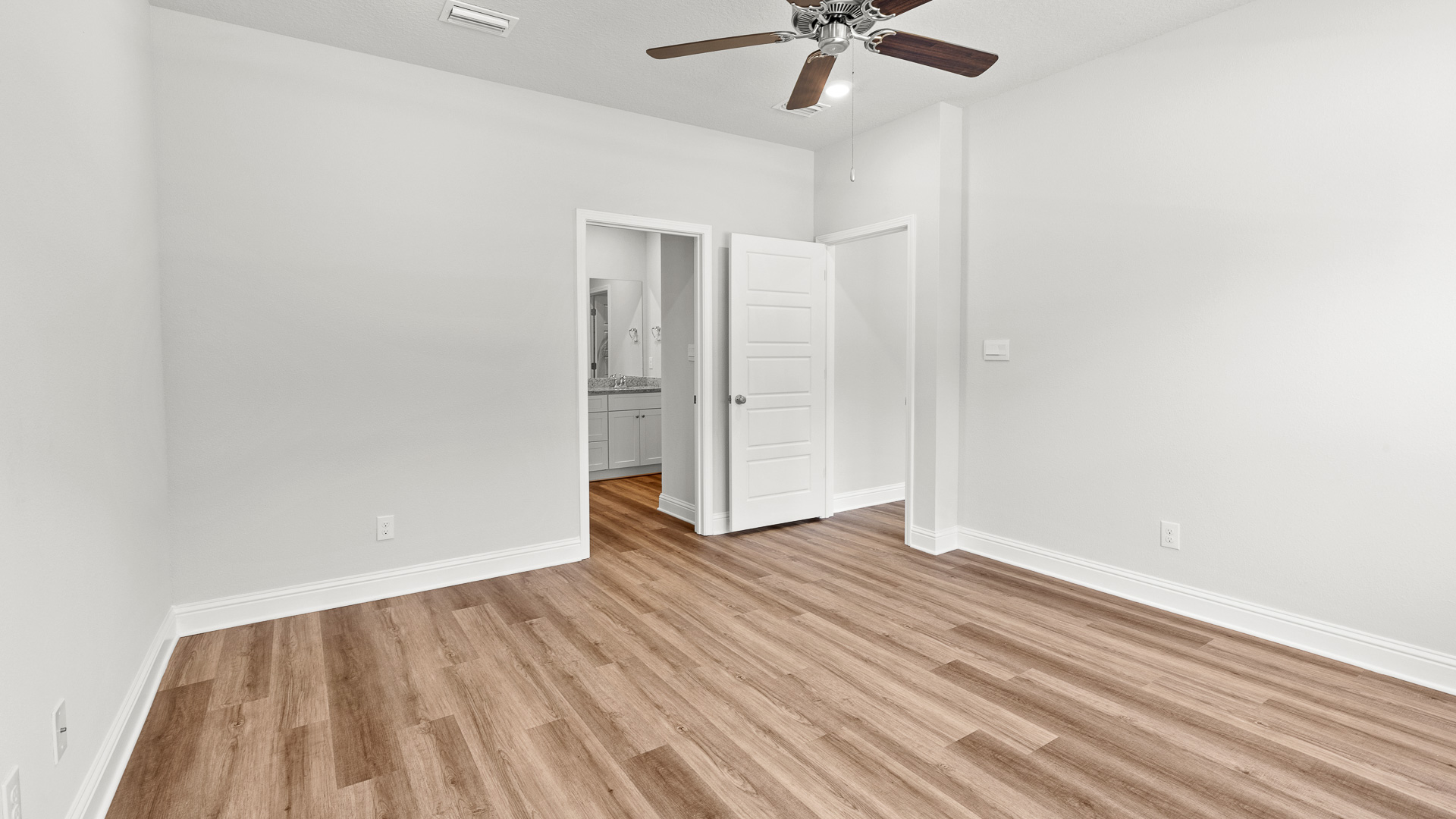 Large primary suite with ensuite bathroom and ceiling fan in Mobile.