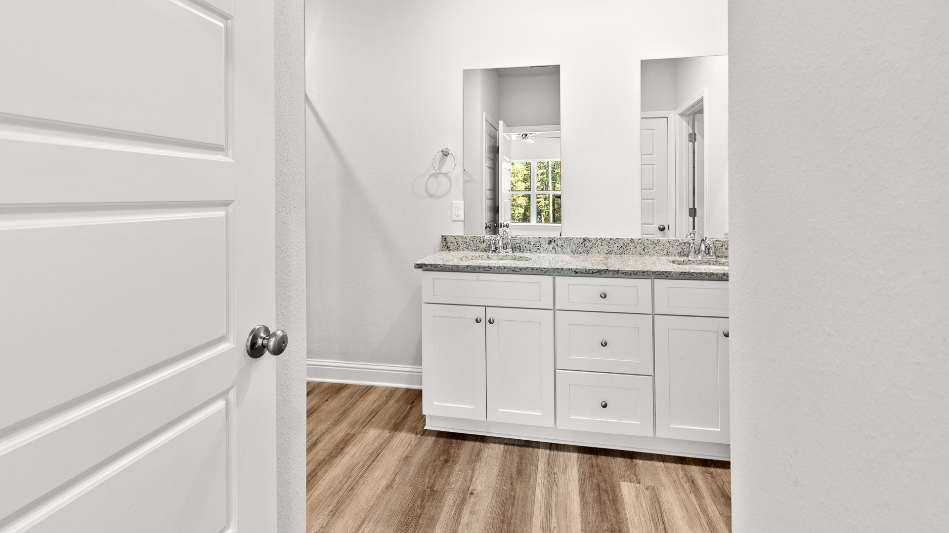 Large primary bathroom with double vanity, undermount sinks, and granite countertop.