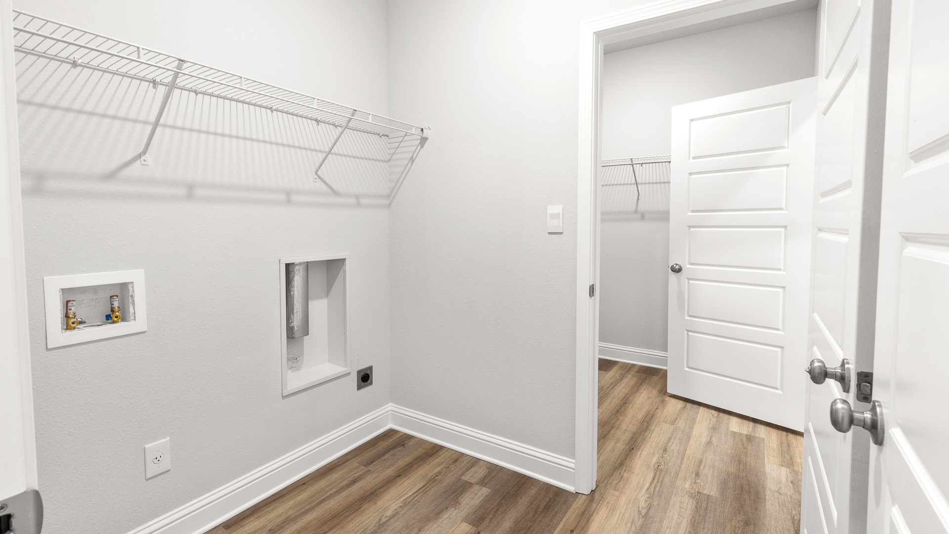 Functional laundry room with shelving for storage in Hawkins Manor.