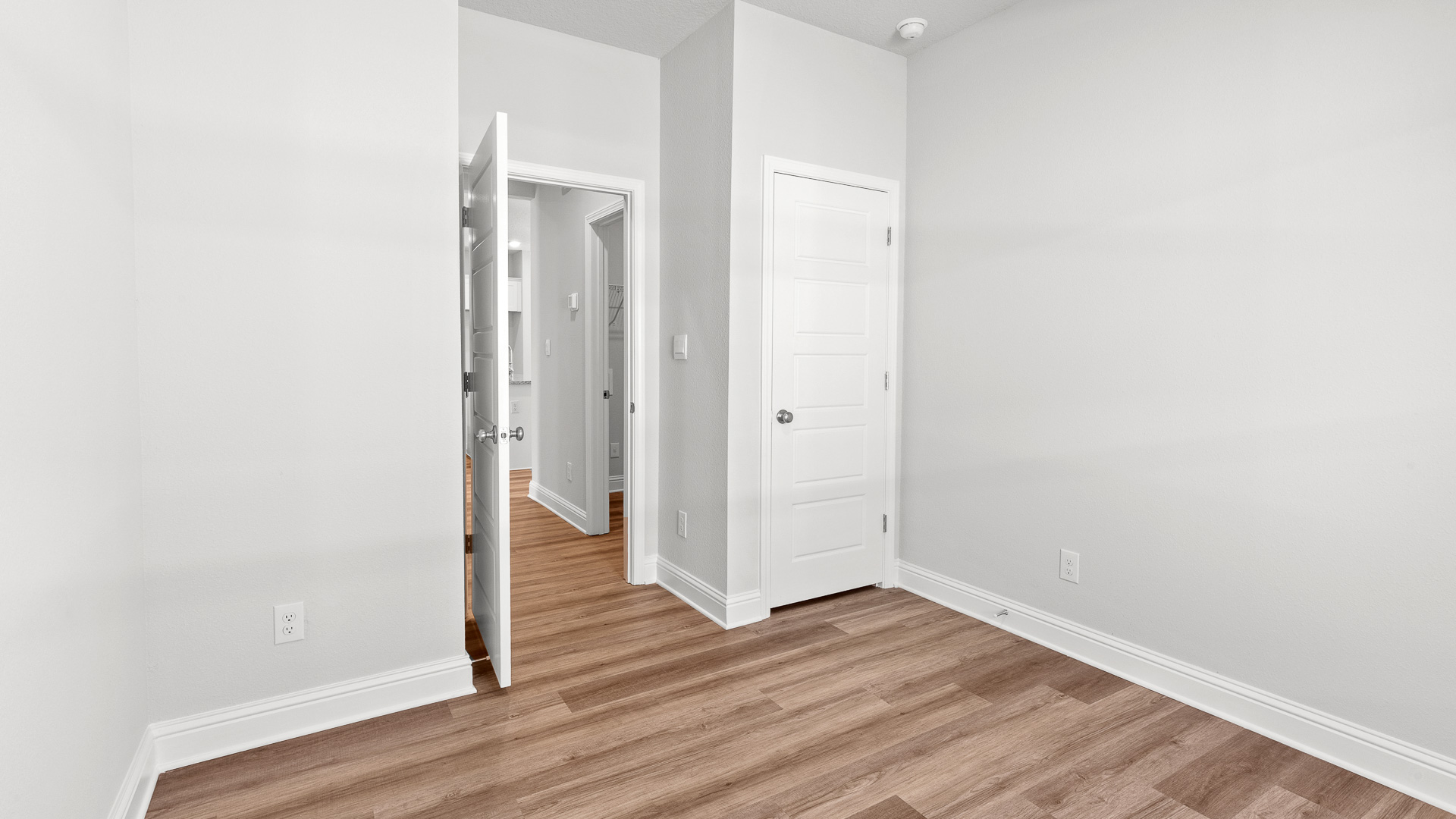 Neutral toned guest bedroom large enough for a full size bed in a new D.R. Horton community in Mobile.