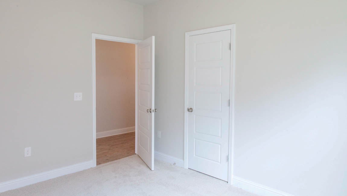 Comfortable guest bedroom with fresh neutral tones in a brand new DR Horton home.