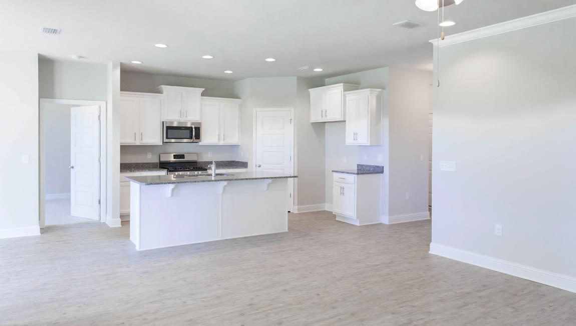 Spacious kitchen with a large island and recessed lighting in a new homes in south Alabama.
