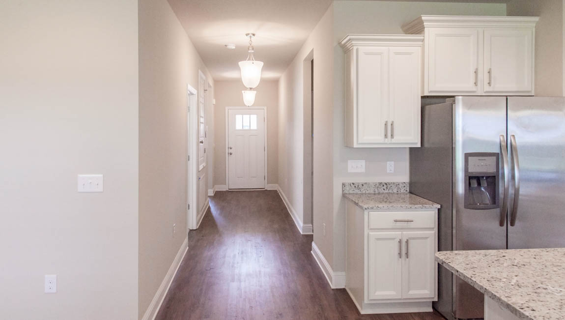Entry way with soft lighting and luxury vinyl plank flooring in a new D.R. Horton community.