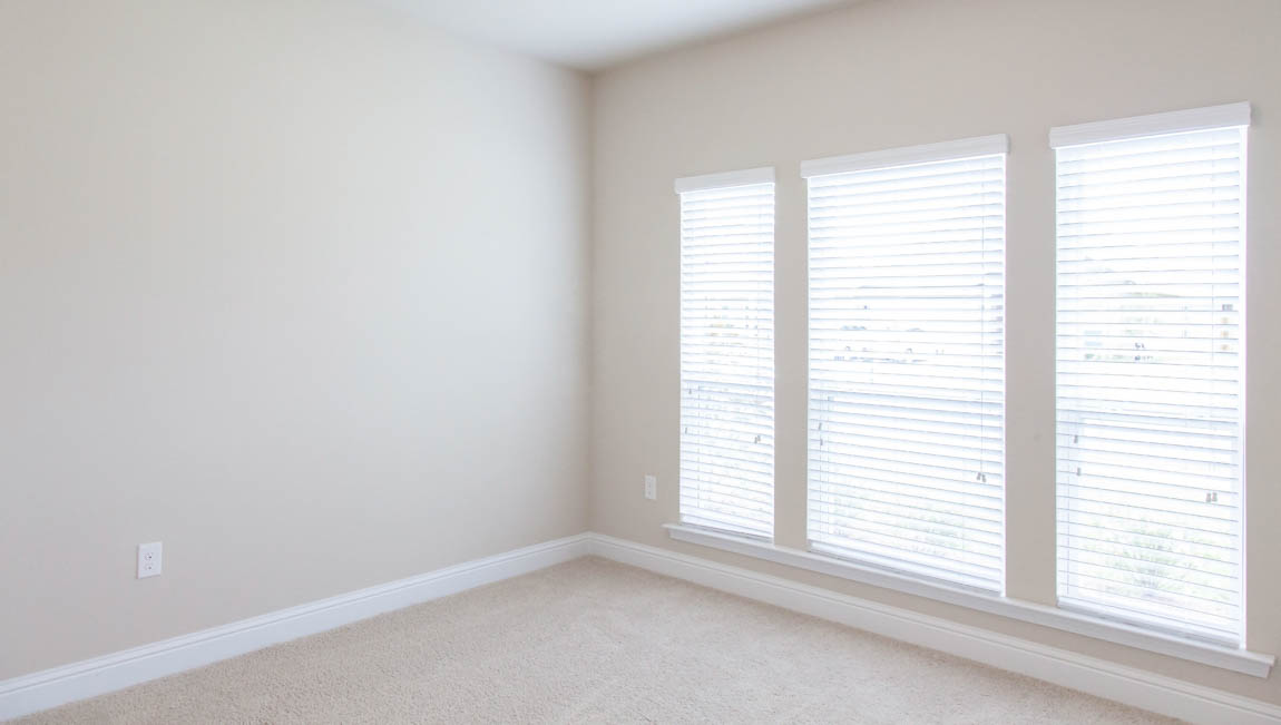 Airy guest bedroom with large window for natural light in Hawkins Manor.