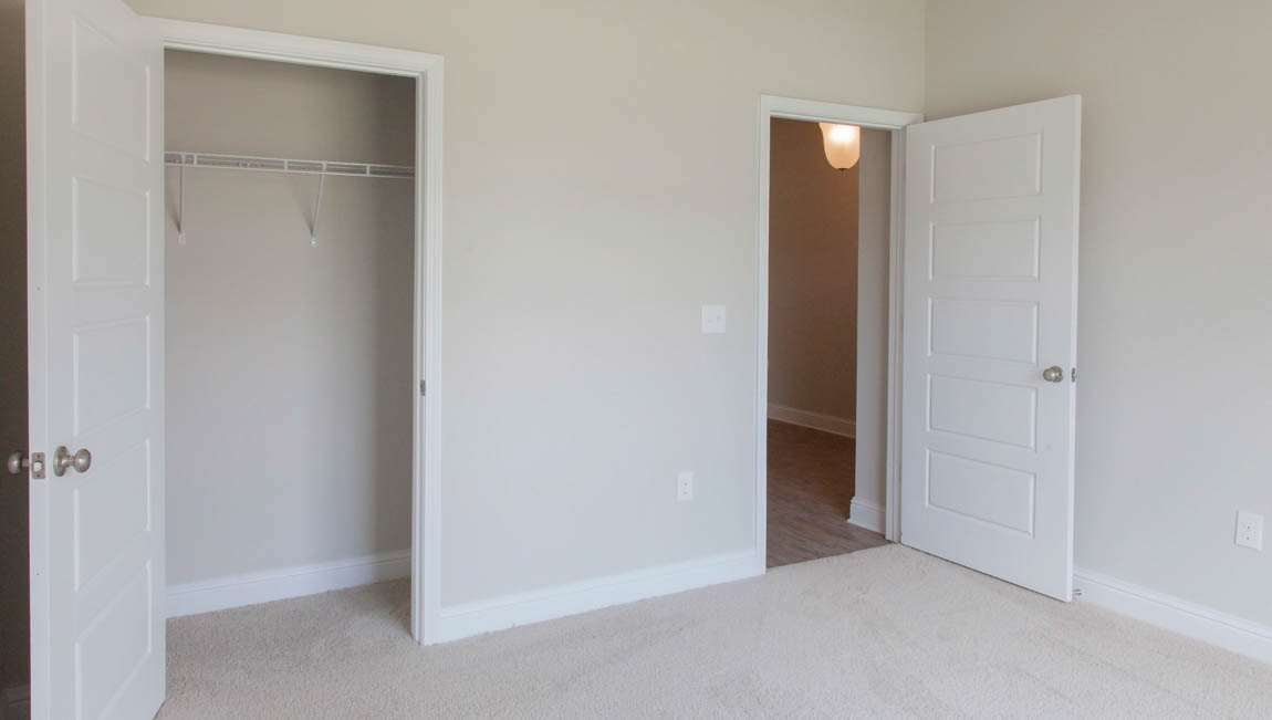Guest bedroom with closet and plush carpet in Hawkins Manor.