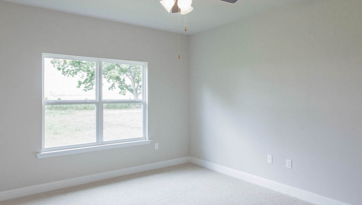 New construction primary suite with soft lighting and ceiling fan by D.R. Horton.