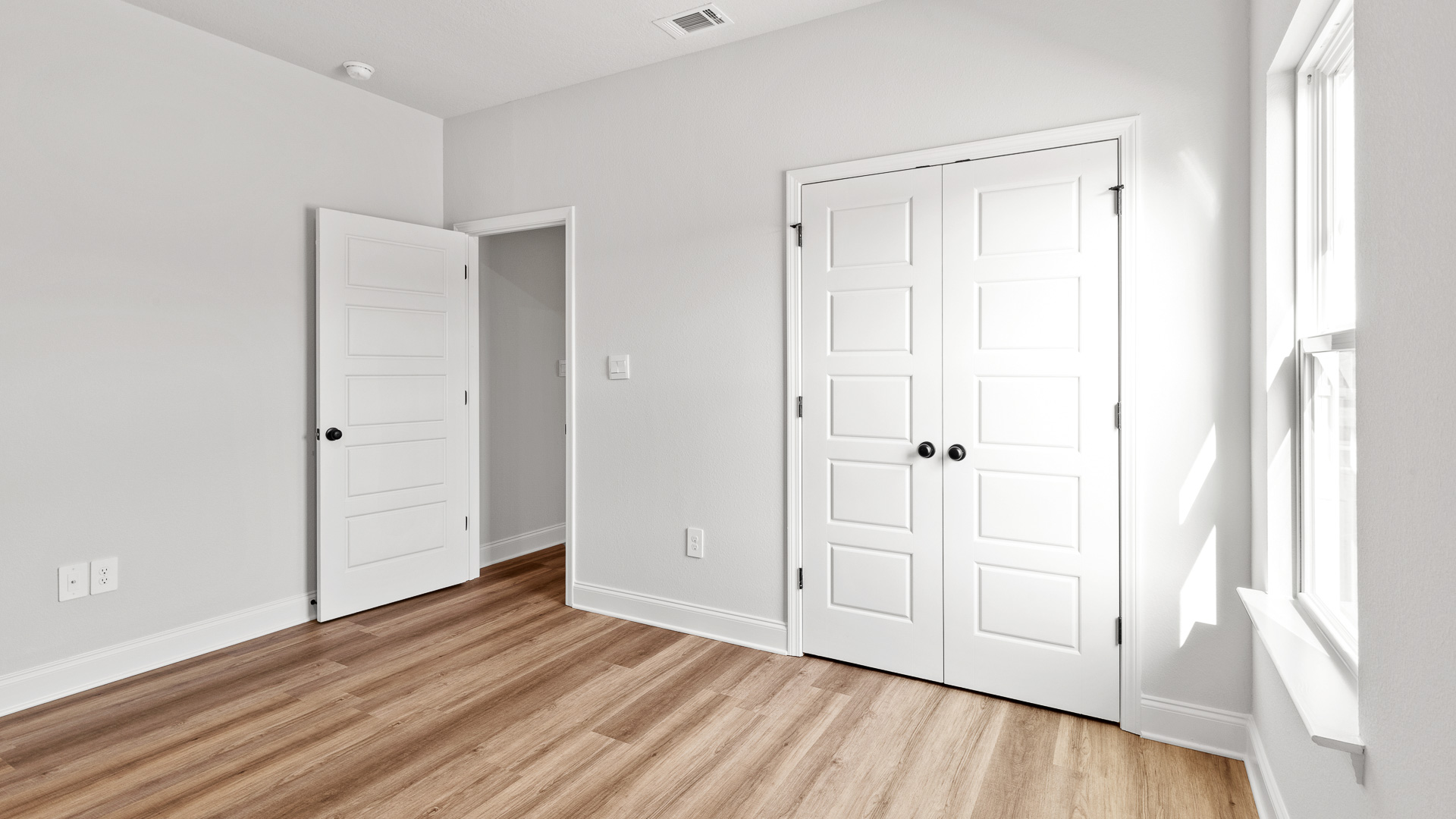 Serene guest bedroom with large closet and window for natural light in Hawkins Manor.