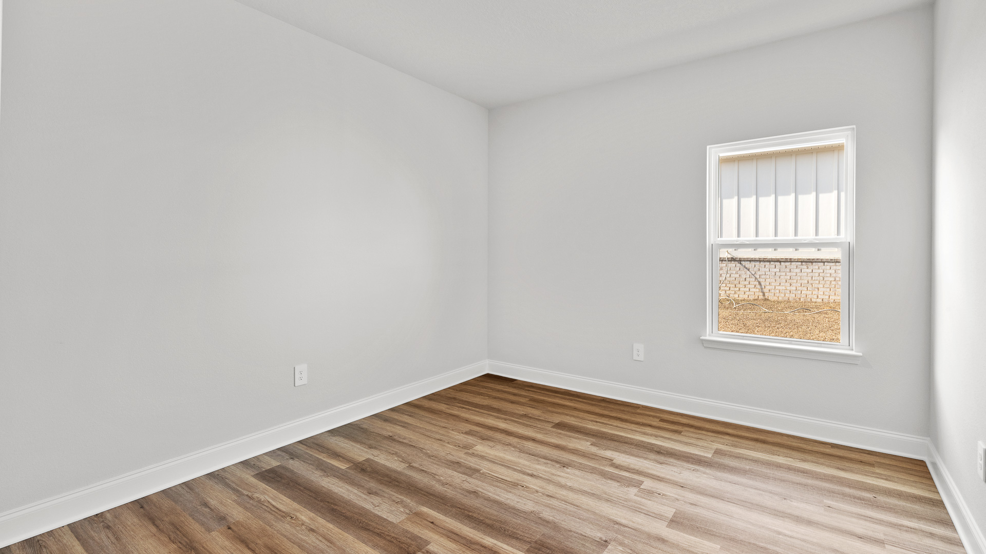 Cozy guest bedroom with a neutral color palette and natural sunlight in Hawkins Manor.