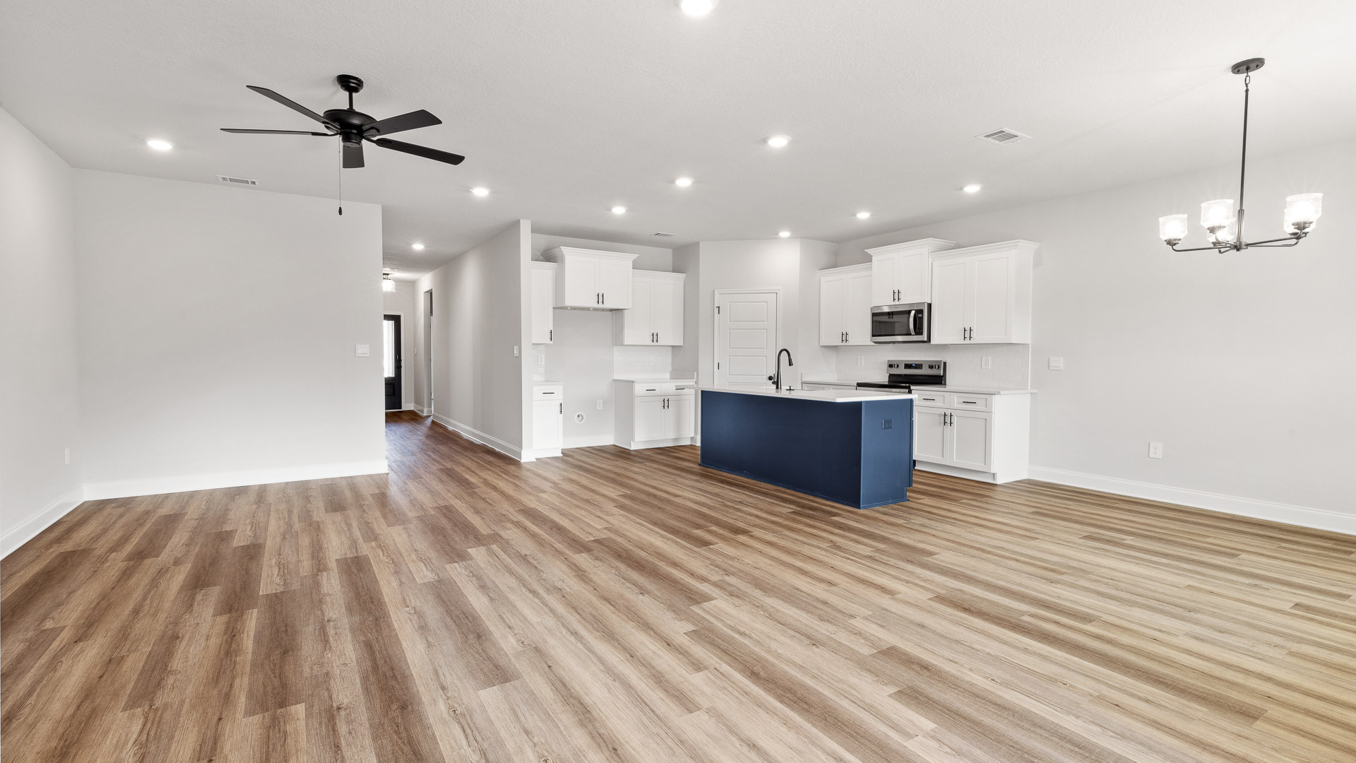 Spacious living area with ceiling fan and neutral color palette in a new construction home built by D.R. Horton.