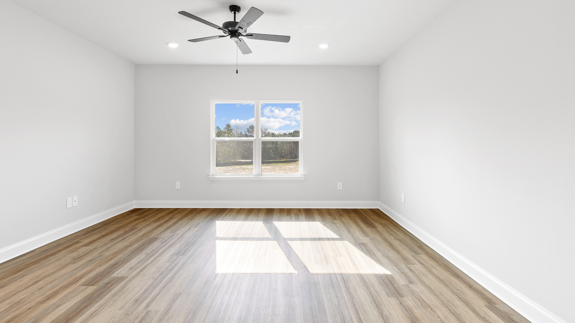 Spacious primary suite with luxury vinyl plank flooring and large window in Hawkins Manor.