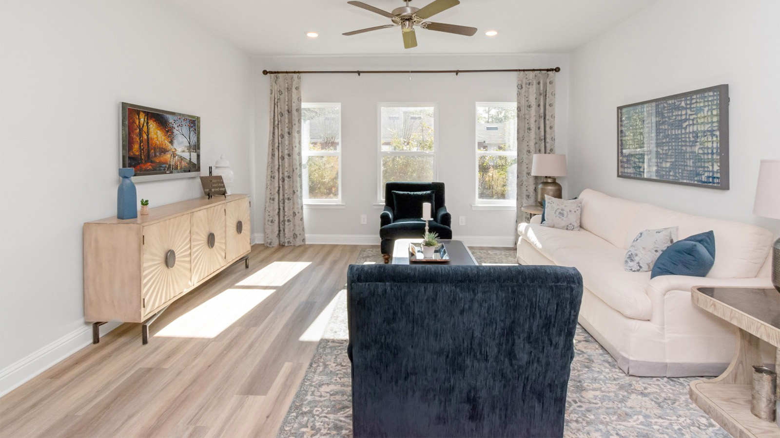 Spacious family room with ceiling fan and soft finishing touches in a new construction D.R. Horton home.