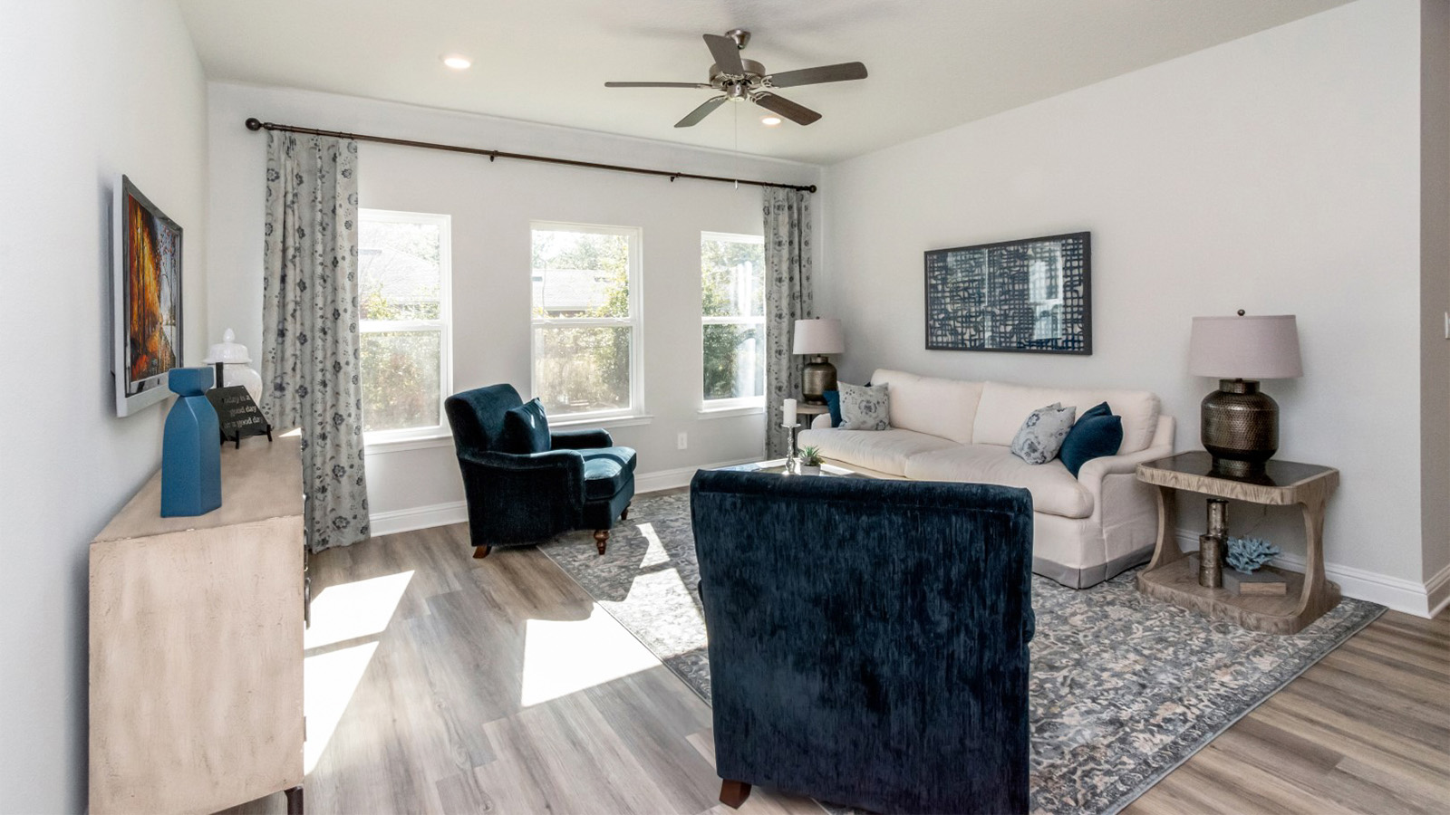 Light filled living area with neutral furnishings and luxury vinyl plank flooring in Hawkins Manor.