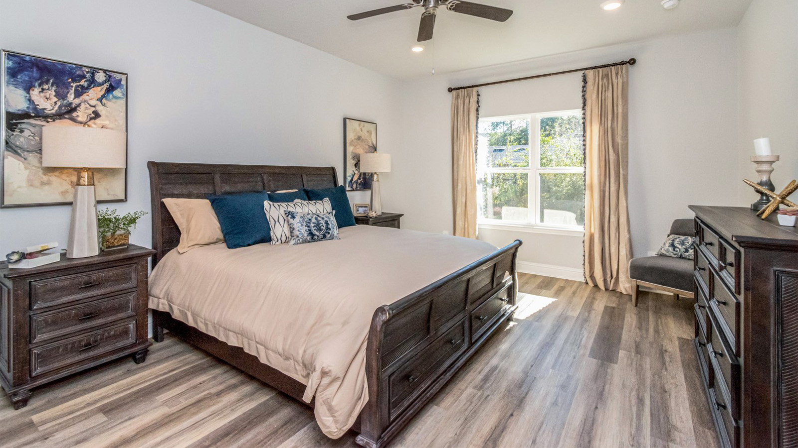 Serene primary suite with ceiling fan and luxury vinyl plank flooring.
