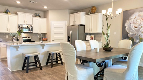 The Dover plan open kitchen with white cabinets at Hawkins Manor