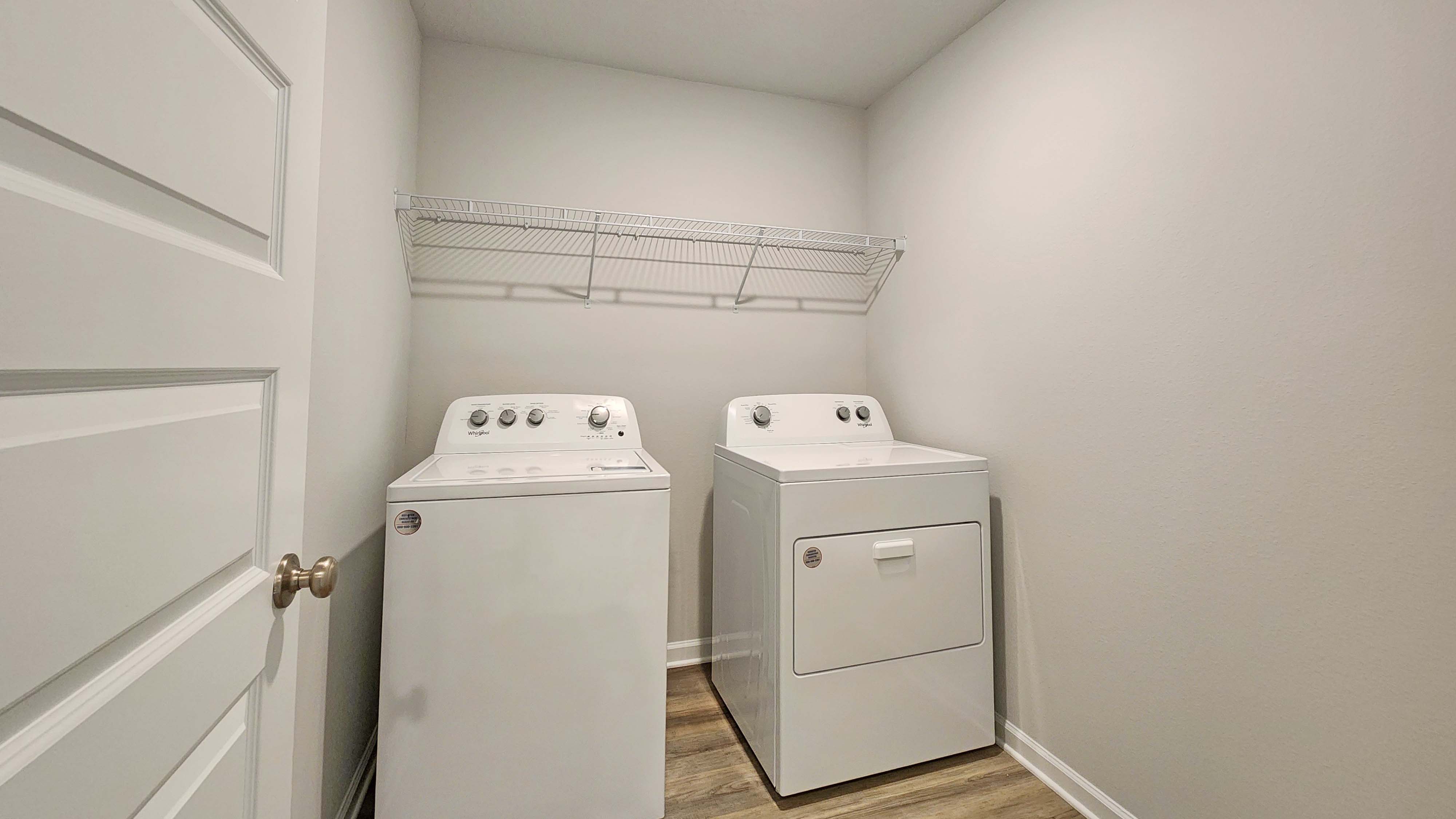Laundry room with shelving above appliances.
