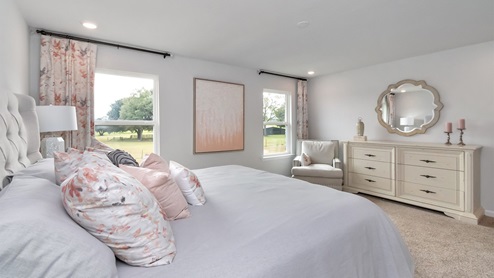 primary bedroom lit up with natural lighting from windows