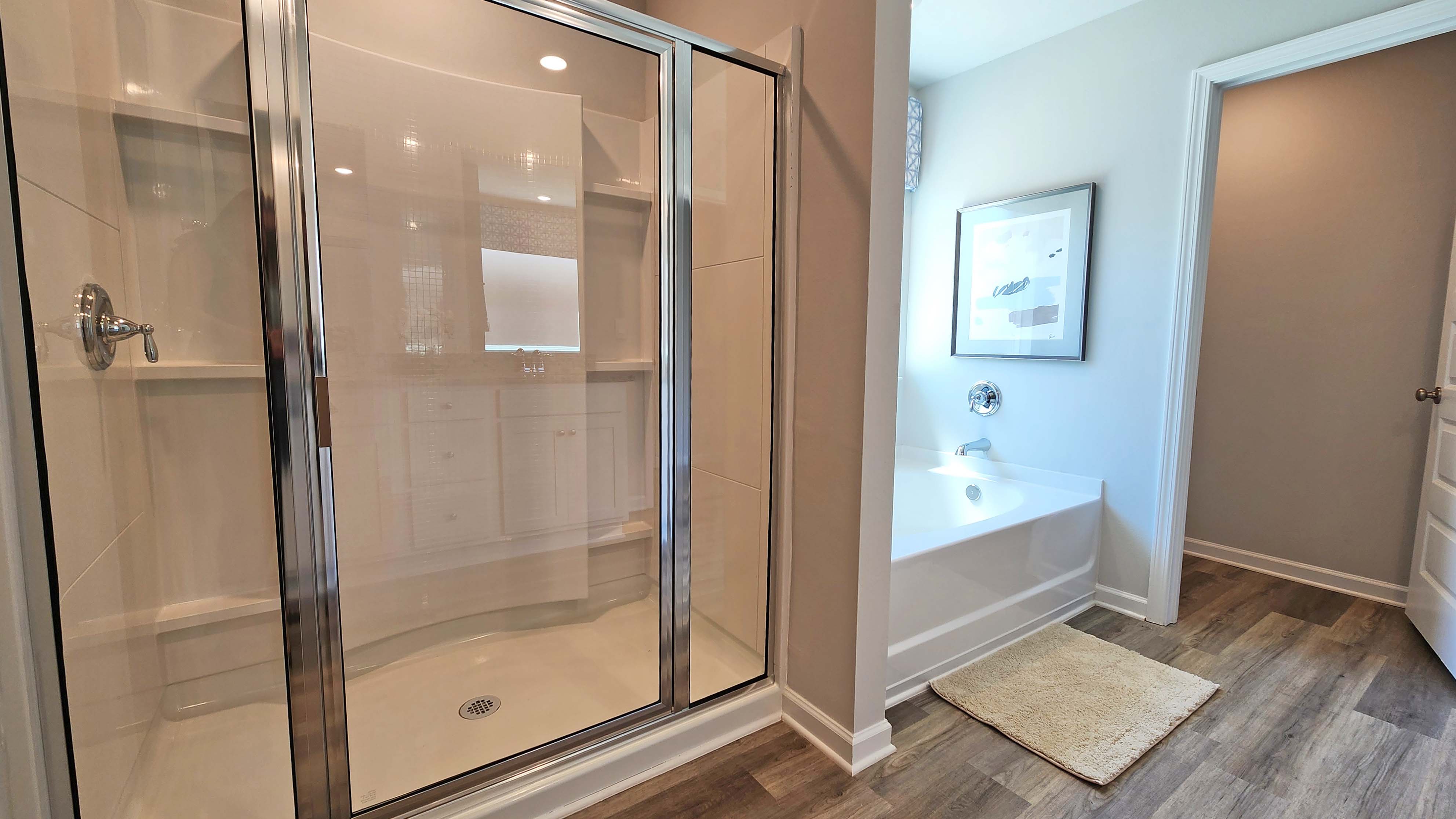 Large primary walking shower with soaking tub in primary ensuite bathroom.
