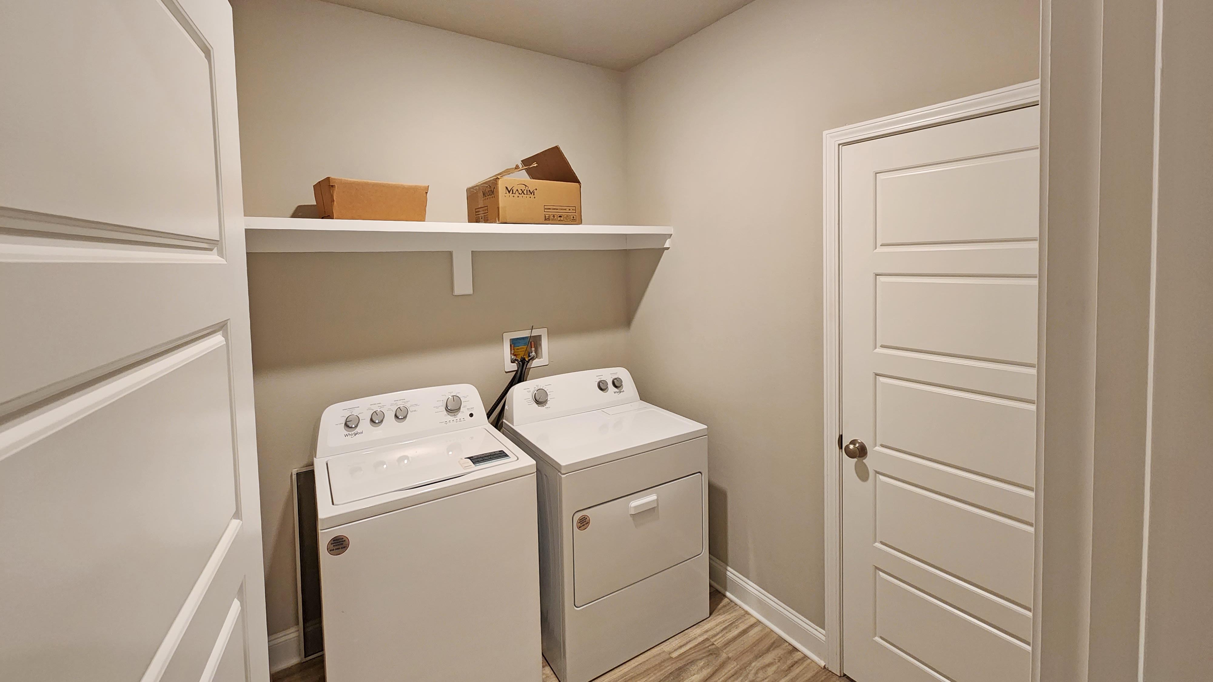 Laundry room with shelving above appliances.