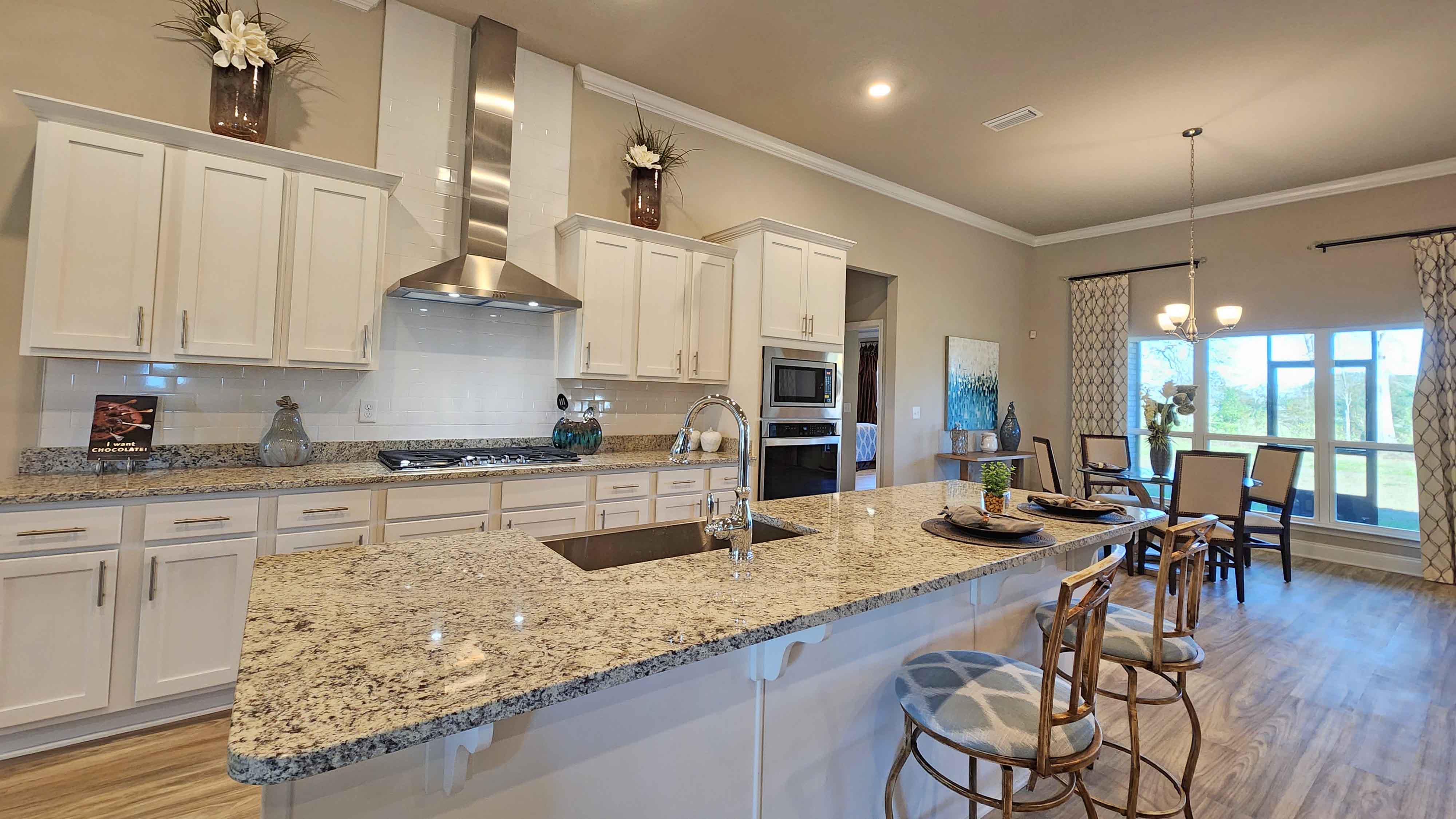 Kitchen featuring cabinets, new stainless steel appliances, and large countertops connecting to dining area.