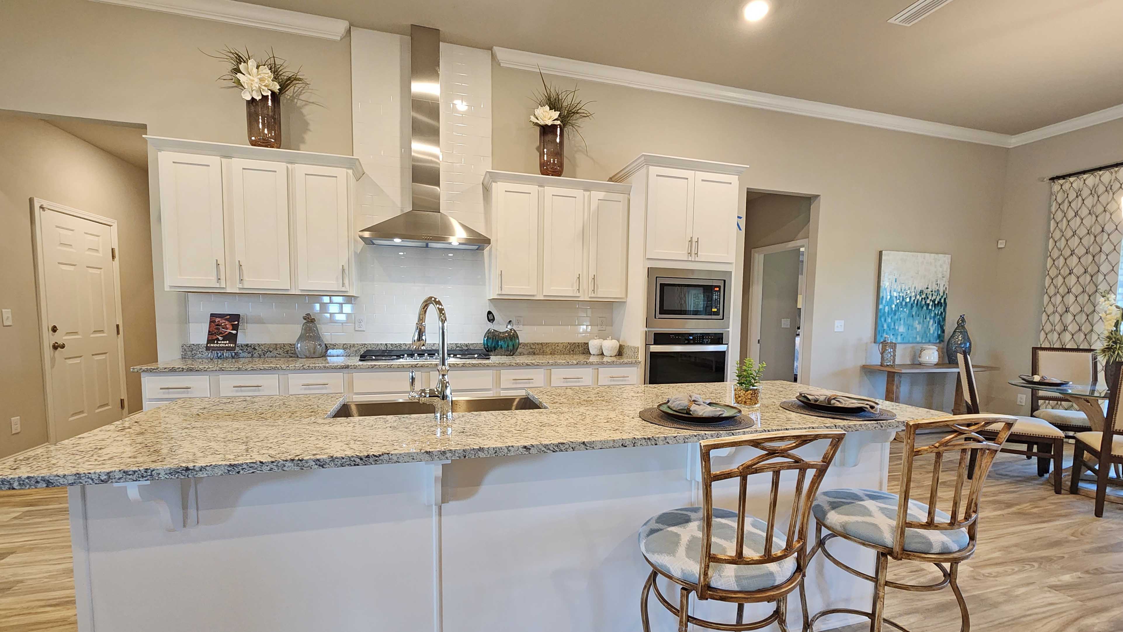 Kitchen showcasing new stainless steel appliances, cabinets, and countertops.