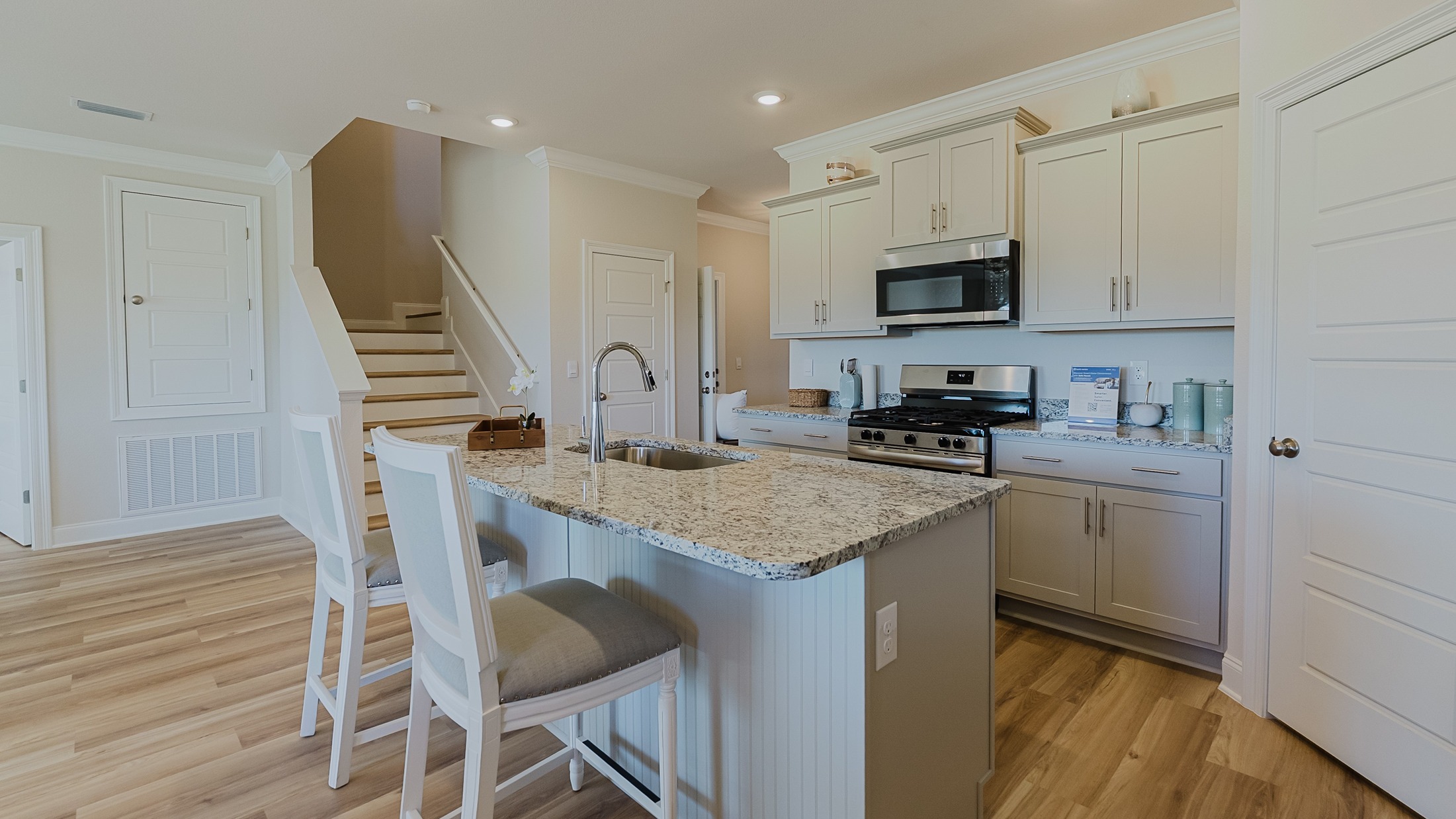 Open concept kitchen across the hall from interior staircase.