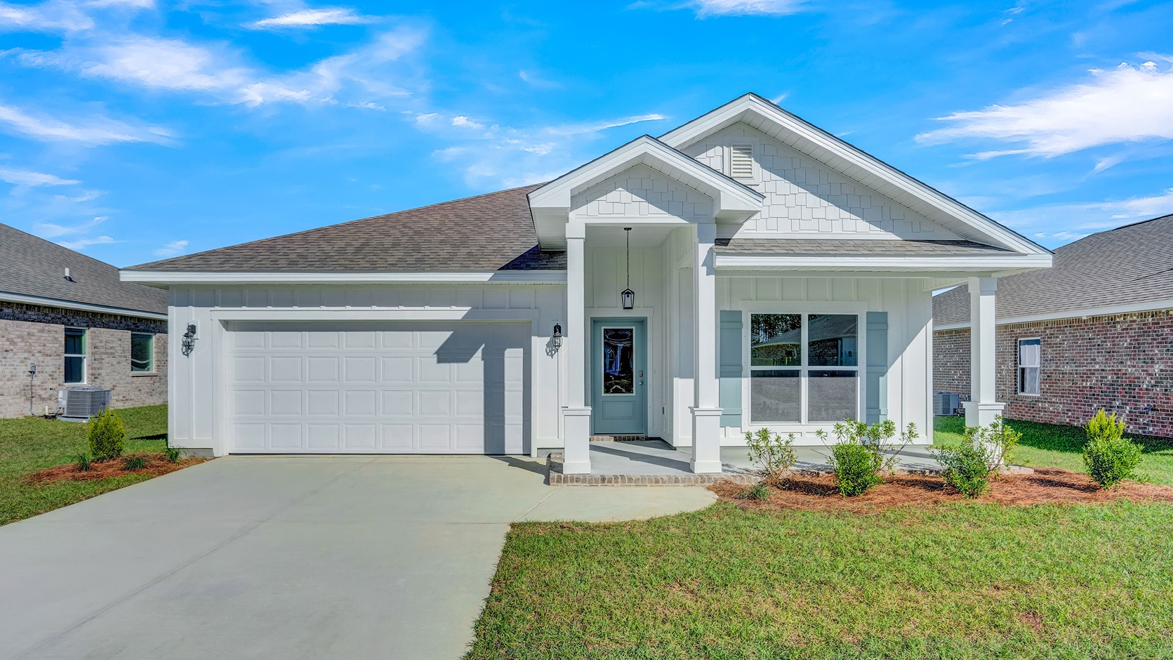 One-story home with board and batten exterior, a covered front porch, and two-car garage.