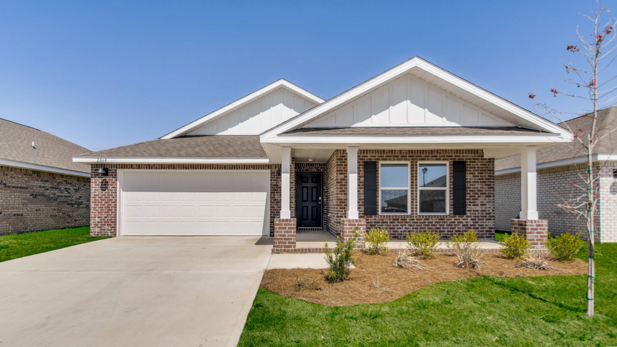 One-story brick home with a covered front porch and two-car garage.