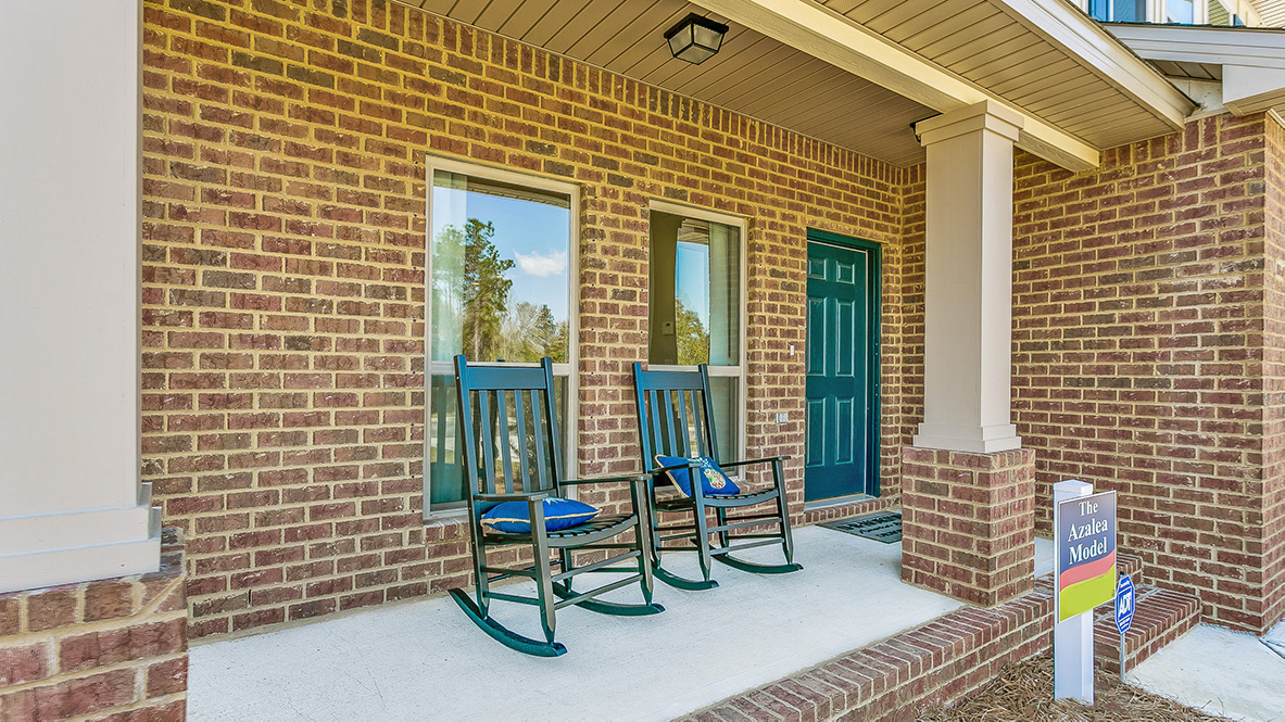 Covered front porch with brick surround and craftsman-style columns.