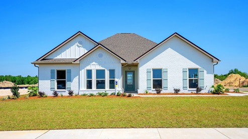 Single-story home with white board and batten exterior and coastal blue shutters.