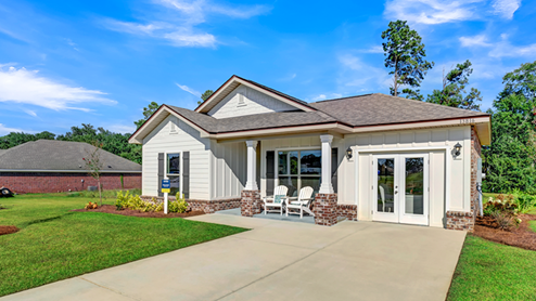 Single-story home with board and batten exterior, a brick water table, craftsman lighting, and a single car garage.