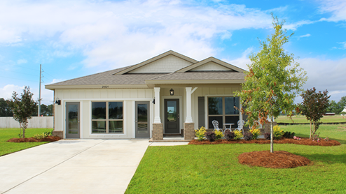 Single-story home with board and batten exterior, brick accents, a covered front porch, and 2-car garage.