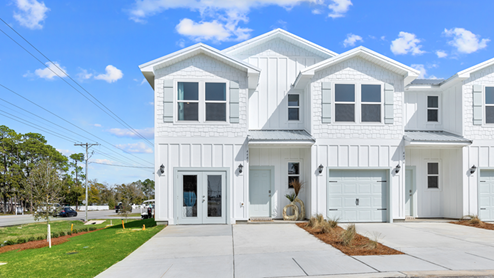 Two-story townhome with board and batten exterior and a one-car garage.