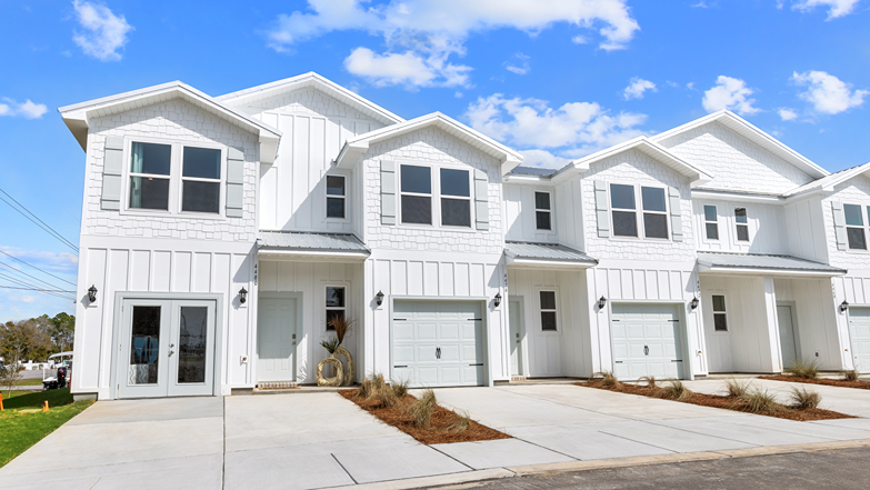 Two-story coastal townhome with a one-car garage.