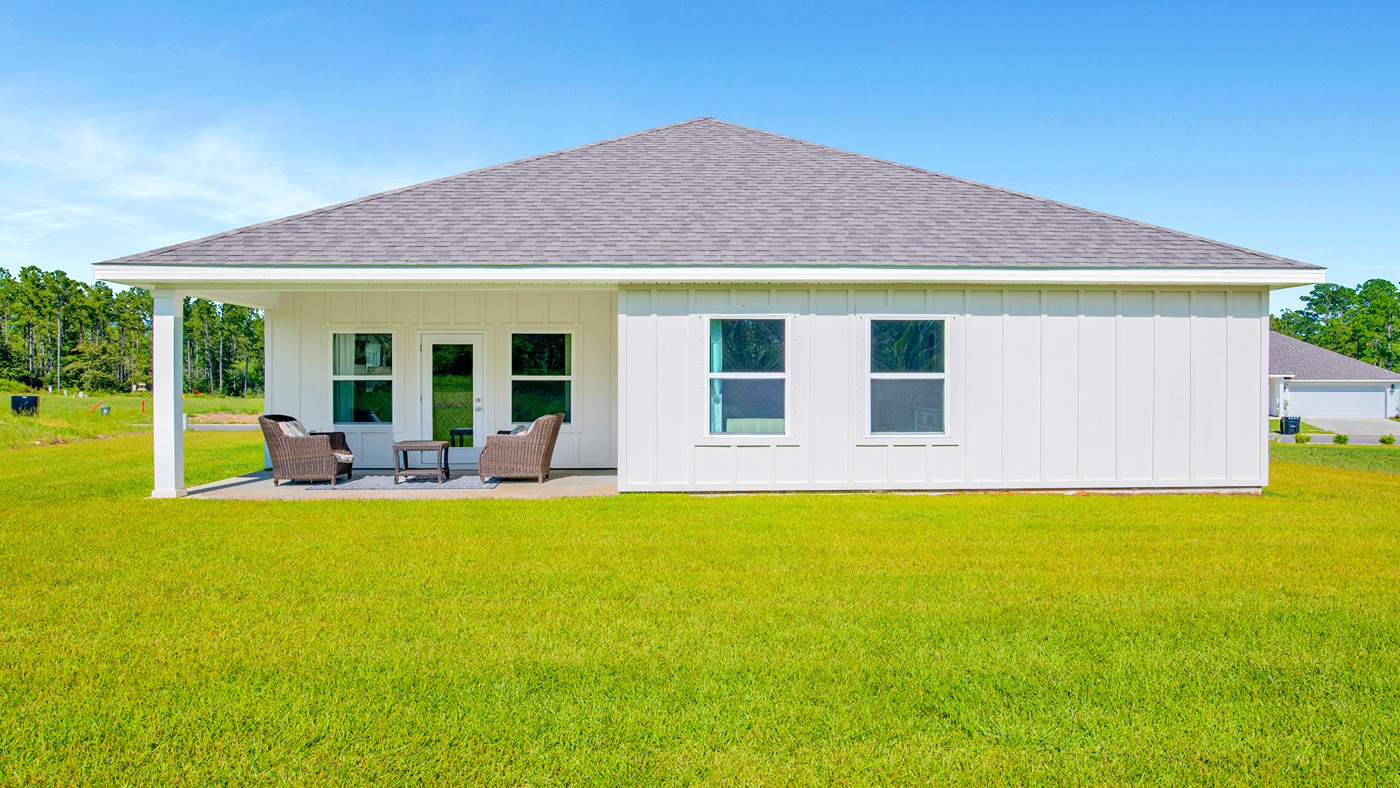 Rear exterior of home with nice green yard.